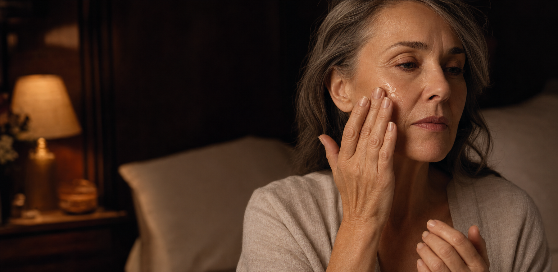 Mujer adulta aplicando aceite facial durante su ritual nocturno